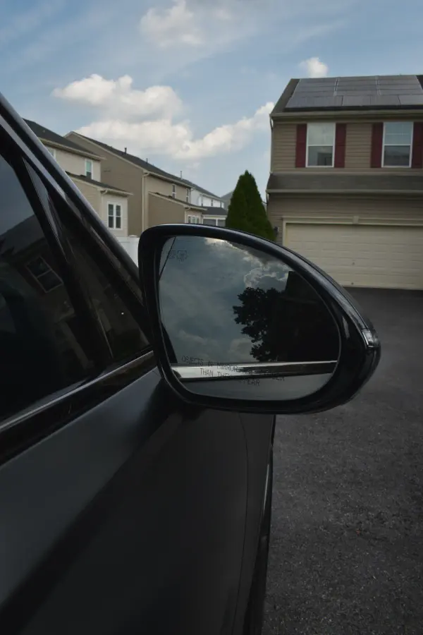 Side mirror reflecting a clear sky after the wash
