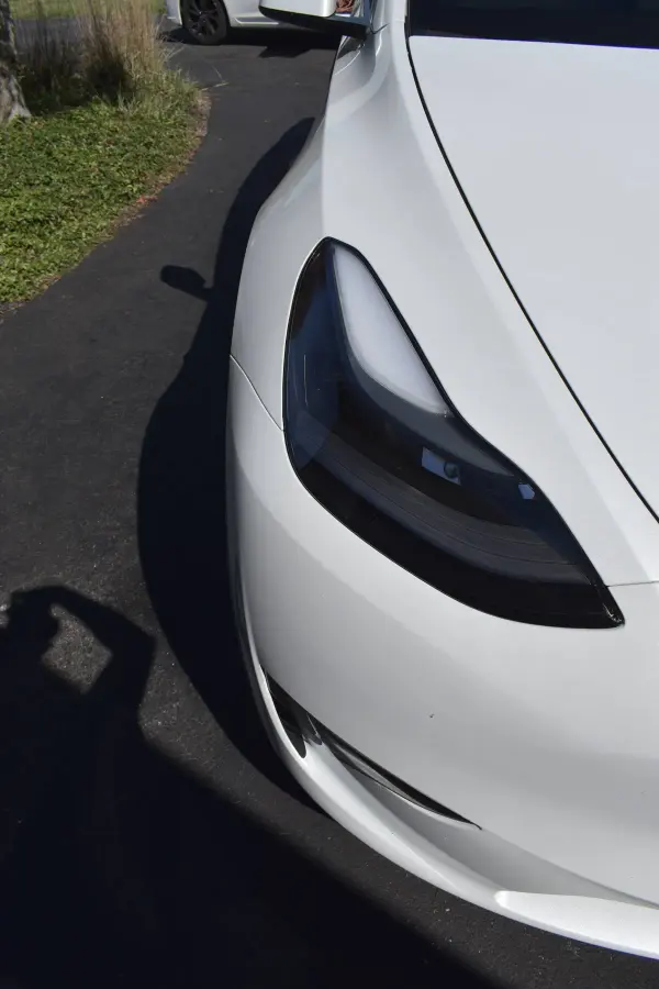 White Tesla headlight and paint after a detail